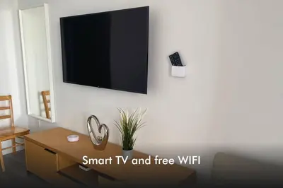 a living room with a tv on a wall at Sun, Sand & Views 1BR Apartment in Miami Beach in Hallandale Beach