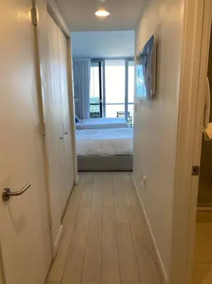 a hallway with a room with a bed and a bedroom at Feel the Miami Vibe , Cozy & Stylish Studio Stay in Hallandale Beach