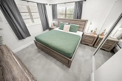 a bedroom with a bed with green sheets and pillows at Holiday Park Apartments by Lowkl in Fort Lauderdale