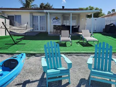 two chairs and a hammock in front of a house at Lakeside Retreat with Private Yard & Kayak in Fort Lauderdale