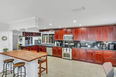 a kitchen with wooden cabinets and a wooden table at Vacation Villa W Heated Pool Beach & Casino in Hollywood