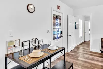 a dining room with a table and a clock on the wall at Hallandale Mins From Beach & Aventura Mall Hn01 in Hallandale Beach