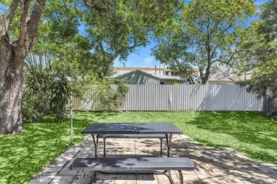 a picnic table and two benches in a yard at Boutique Vacation Studio - Beach, Mall, Casino Hn2 in Hallandale Beach