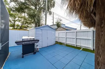 a backyard with a grill and a white fence at Private Heated Pool Villa in FTL Near Beach in Fort Lauderdale