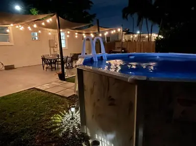 a swimming pool with lights in a backyard at night at Coral Gables Home with POOL Near Airport. King beds in Miami