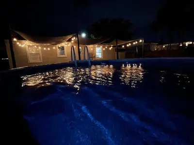 a swimming pool lit up at night with lights at Coral Gables Home with POOL Near Airport. King beds in Miami