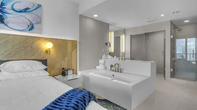 a bedroom with a bed and a tub and a sink at Your Private Oceanfront Sanctuary 2BR 2BA in Fort Lauderdale