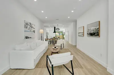 a white living room with a white couch and chairs at Radiance - Modern Design, Poolside Escape in Miami