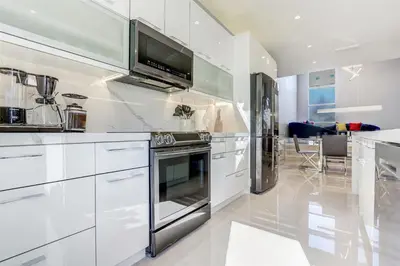 a kitchen with white cabinets and a stove at Deco Delight - Central Hub in Miami