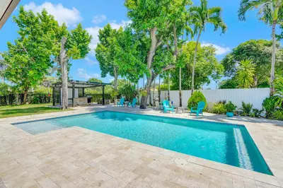 a swimming pool in a yard with trees at The Gardens - Luxe, Pool, Mins to Hard Rock Stadium in Miami Gardens