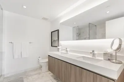 a white bathroom with a sink and a toilet at Tiffany Hazel - Rooftop Pool, Gym, & Walk to Beach in Fort Lauderdale