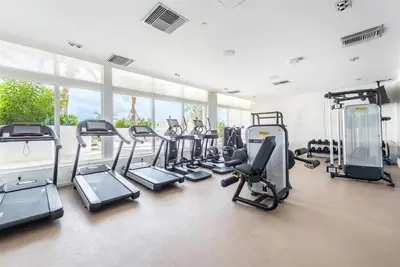 a gym with a bunch of treadmills and ellipticals at Tiffany Blanca - Rooftop Pool, Gym, & Walk to Beach in Fort Lauderdale