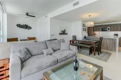 a living room with a couch and a table at Tiffany Blanca - Rooftop Pool, Gym, & Walk to Beach in Fort Lauderdale