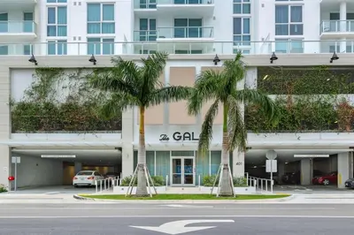 a building with palm trees in front of a street at Tiffany Coral - 6th FL, Pool, Gym, & Mins to Beach in Fort Lauderdale
