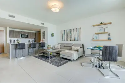 a living room with a couch and a table at Tiffany Coral - 6th FL, Pool, Gym, & Mins to Beach in Fort Lauderdale