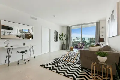 a living room with a couch and a rug at Tiffany Sage - Rooftop Pool, Gym, & Walk to Beach in Fort Lauderdale