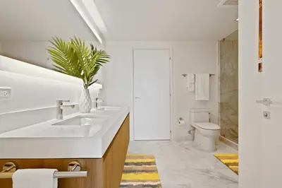 a white bathroom with a sink and a toilet at Tiffany Sage - Rooftop Pool, Gym, & Walk to Beach in Fort Lauderdale
