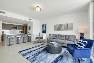 a living room with a couch and a kitchen at Tiffany Indigo - Rooftop Pool, Gym, Walk to Beach in Fort Lauderdale