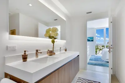 a white bathroom with a sink and a mirror at Tiffany Indigo - Rooftop Pool, Gym, Walk to Beach in Fort Lauderdale