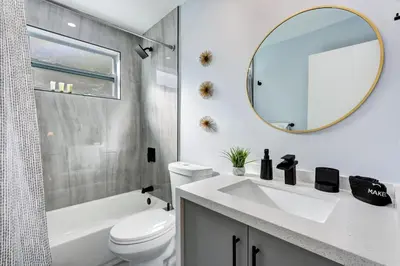 a white bathroom with a sink and a mirror at Renovated professional design, grill lake view! in Hallandale Beach