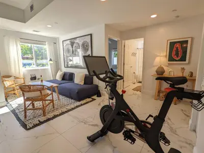 a living room with a exercise bike and a couch at Artease 2 -Largest, stylish, Peloton bike, near Wynwood Walls & restaurants in Miami