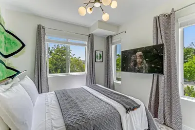 a bedroom with a bed and two windows at ArTease3 - stylish, near Wynwood Walls & restaurants in Miami