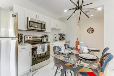 a kitchen with a table with chairs and a refrigerator at ArTease3 - stylish, near Wynwood Walls & restaurants in Miami