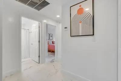 a hallway with white walls and a painting on the wall at ArTease5 - stylish, near Wynwood Walls & restaurants in Miami