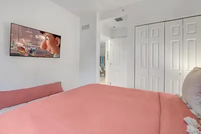 a bedroom with a pink bed and a tv on the wall at ArTease5 - stylish, near Wynwood Walls & restaurants in Miami