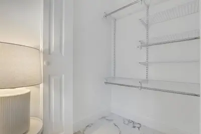 a white bathroom with a toilet and shelves at ArTease5 - stylish, near Wynwood Walls & restaurants in Miami