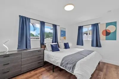 a bedroom with a large bed with blue curtains at Escape to Private Poolside Bliss in Hollywood
