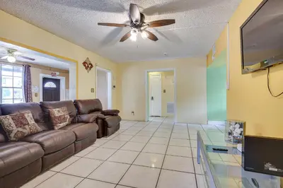 a living room with a couch and a ceiling fan at 4 Mi to Beach Hollywood Home with Patios! in Hollywood
