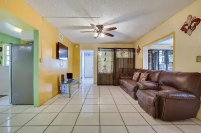 a living room with a couch and a ceiling fan at 4 Mi to Beach Hollywood Home with Patios! in Hollywood