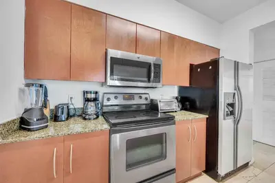 a kitchen with a stove and a microwave and a refrigerator at Modern 1 Bed in the Heart of Brickell With Free Parking in Miami