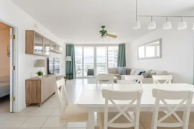 a white kitchen and living room with a table and chairs at Pavilion - Stunning bay view in Miami Beach