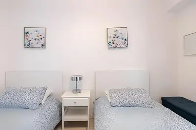two beds in a bedroom with two pictures on the wall at Pavilion - Stunning bay view in Miami Beach