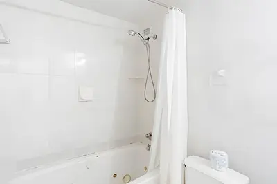 a white bathroom with a tub and a shower at Pavilion - Stunning bay view in Miami Beach