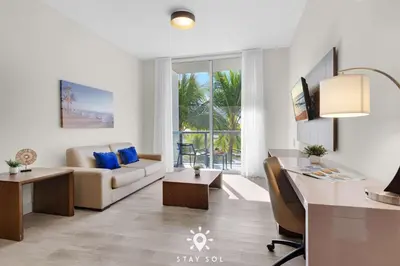 a living room with a couch and a desk at Hot Tub - Hollywood Beach Boardwalk - Amazing Pool in Hollywood