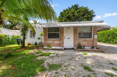 a house with a palm tree in front of it at 3BR Boho Style Home w Private yard & Firepit in Miami
