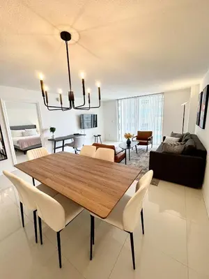 a living room with a wooden table and chairs at 36th floor Brickell bay view 1BR 2 Queens and Sofa Bed in Miami