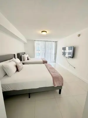 a bedroom with two beds and a large window at 36th floor Brickell bay view 1BR 2 Queens and Sofa Bed in Miami