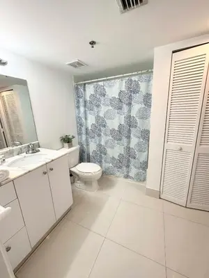 a white bathroom with a toilet and a shower at 36th floor Brickell bay view 1BR 2 Queens and Sofa Bed in Miami