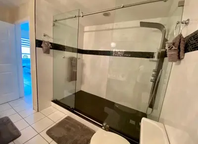 a glass shower in a bathroom with a toilet at Large beautiful penthouse ocean front with beach access and free parking in Miami Beach in Miami Beach