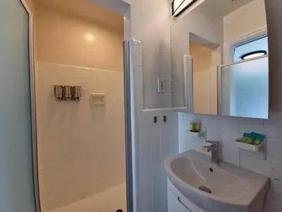a white bathroom with a sink and a shower at Quiet Oasis Steps From Shops with Golf View-CS61 in Hollywood