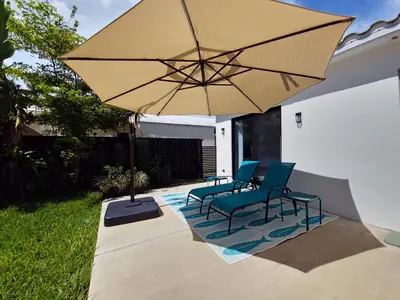 a patio with two chairs and a large umbrella at Quiet Oasis Steps From Shops with Golf View-CS61 in Hollywood