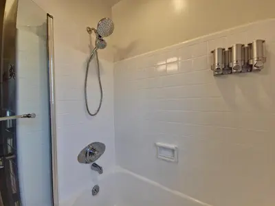 a white bathroom with a shower with a shower head at Quiet Oasis Steps From Shops with Golf View-CS61 in Hollywood