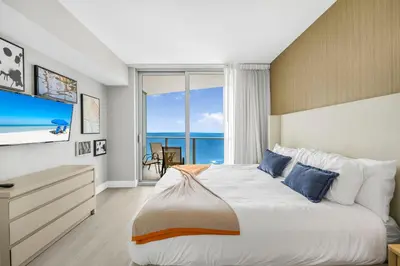 a bedroom with a large bed with a view of the ocean at Elegant Beachfront Condo Offering Stunning Views in Hollywood