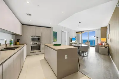 a large kitchen with a table and a dining room at Elegant Beachfront Condo Offering Stunning Views in Hollywood