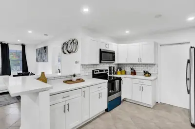 a white kitchen with white cabinets and appliances at Cozy Fun House 4 2 Aventura Stadium Beach in North Miami Beach