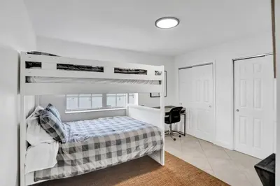 a bedroom with a bunk bed and a desk at Cozy Fun House 4 2 Aventura Stadium Beach in North Miami Beach